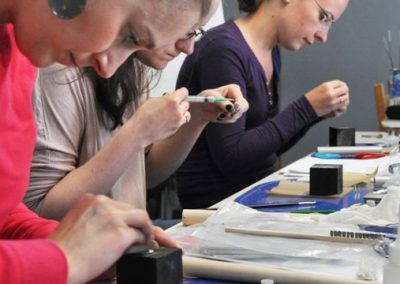 Art Clay Silver ezüstgyurma workshop résztvevői elmélyülve ezüstgyűrű díszítése közben, amit fecskendős technikával végeznek.